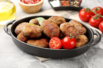 Tasty meat patties served on grey textured table, closeup