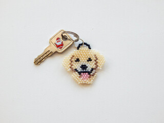 Children's keychain in the shape of a dog on a white surface