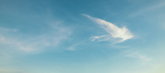 the sky is clear blue with fluffy white clouds, the sky is very bright, and the sun shines.