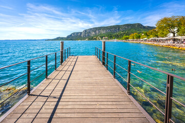 Fototapeta premium Wooden Pier on Lake Garda Waterfront at Garda Village, Veneto, Italy