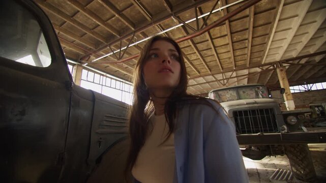 Woman explores an abandoned warehouse filled with vintage items and history