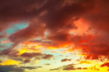 Dramatic sunset sky swirls with deep in fiery orange clouds. Ethereal glow evokes a fiery,...