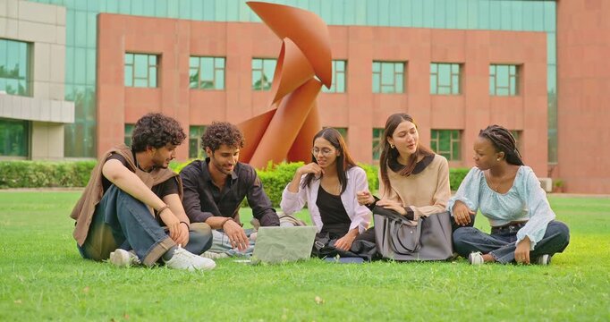 Indian young adult gen z woman lady male man talk gossip share new plan enjoy day spend break time park. Happy pupil girl boy group use laptop look screen do study check online e work garden place