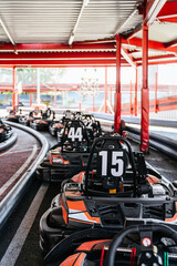Go karts numbered 15 and 44 lined up on an outdoor track in daylight, parked and prepped for racing, colorful and ready for action © Koldo_Studio