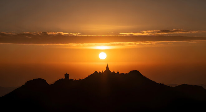 Pagodas silhouette at sunset on mountain ridge dramatic orange sky