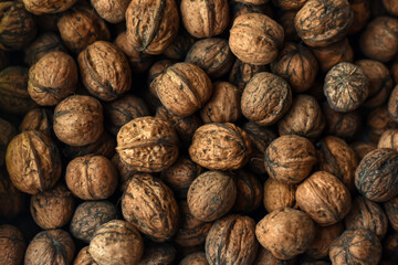Walnuts texture. A lot of walnuts. Healthy organic food concept. Blurred photo for background.Brown big walnuts, top view.