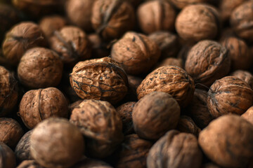 Walnuts texture. A lot of walnuts. Healthy organic food concept. Blurred photo for background.Brown big walnuts, top view.