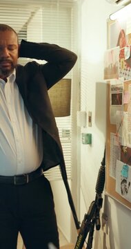 Detective, anxious and man with board, police station and frustrated with lack of evidence or clues. Disappointed, mature investigator and black person with unsolved murder investigation and deadline