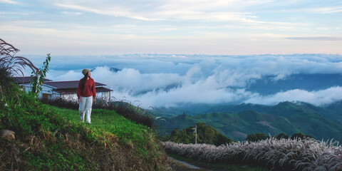 A woman standing and looking at a mountain views outside the resort on foggy morning