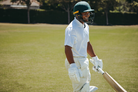 Smiling batsman wearing helmet on a warm day at the cricket field