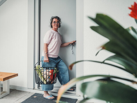 Woman with groceries entering house using smart key