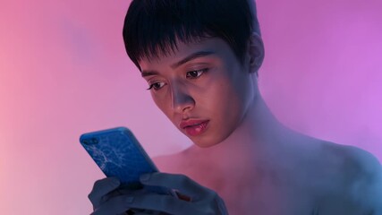 Tapping Asian female model interacting with cracked smartphone in studio, with swirling colored fog - Powered by Adobe