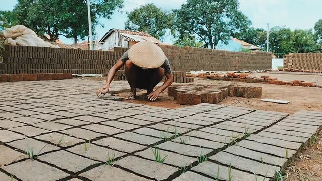 
Close Up. Brick factory in Tegal village, Indonesia. The row of red bricks. Typical working day at a brick factory.
