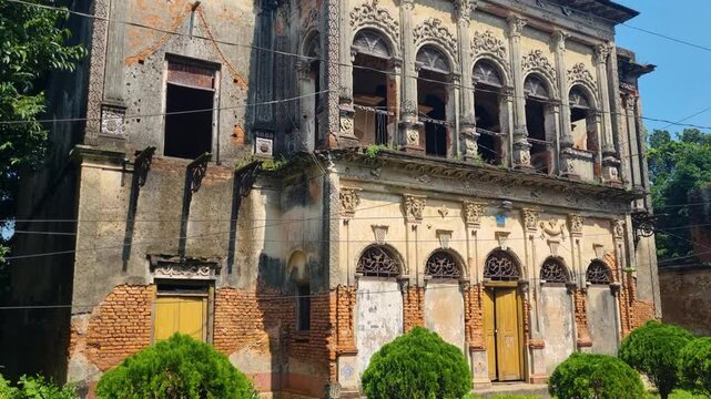 Historic colonial architecture stands in decay at a crumbling mansion in Panam Nagar, Bangladesh, bathed in warm autumn sunlight, revealing faded grandeur and weathered walls