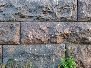 Close-up of weathered grey stone castle wall with staggered joints. Surface shows chips and...