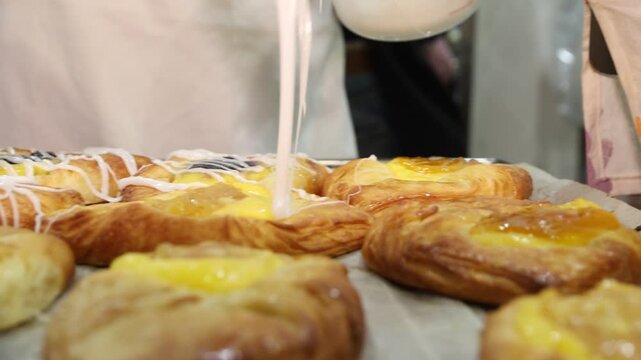 A close-up of pastries being iced at the Farina Underground Bakery. A volunteer adds the finishing touches to these delicious treats in this historic outback location.