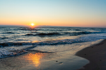 Golden sunrise over the North Sea with soft waves and reflections