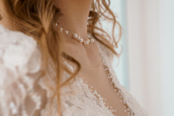 Elegant Bride Adorns Pearl Necklace. Wedding Day Close-Up. Soft Focus. Romantic Lace. Cream and...