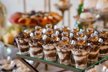 Elegant Wedding Dessert Display Featuring Chocolate Mousse Shooters with Heart-Shaped Garnishes on...