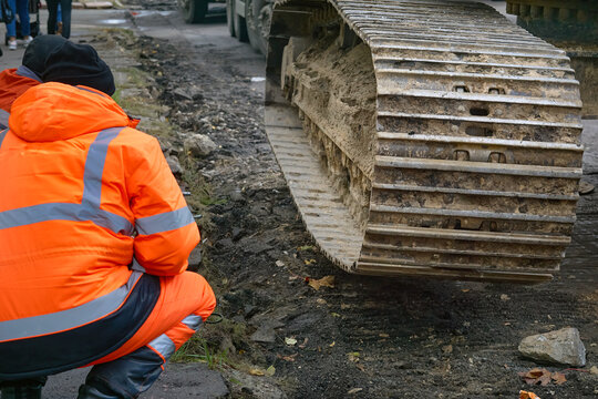 Road works.Driver inspects the damage to the track of a tractor,bulldozer