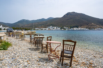 Tables and chairs on the beach in Xilokeratidi, facing the Katapola harbor. Amorgos, Cyclades, Greece