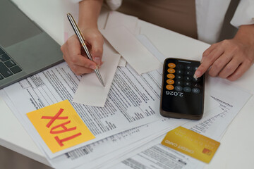 Tax assessment. Individual calculating tax liabilities with documents.