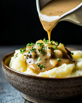 Gravy being poured over gourmet mashed potatoes