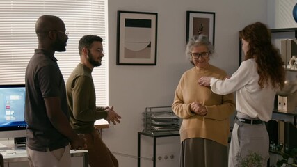 Ethnically diverse young colleagues congratulating senior woman with retirement, women getting touched by their words then hugging them