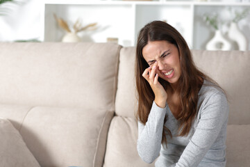 Woman complaining scratching eye at home