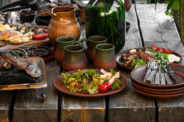 tasty meal grilled food meat and vegetables on rustic huge wooden table outdoor patio restaurant cuisine European aesthetic concept