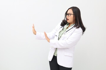Displeased asian adult doctor woman wearing doctor's suit, white background keeps hands to sideways...