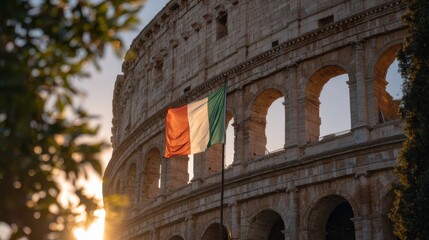 Obraz premium Sunset view of the Colosseum with the Italian flag waving in the foreground