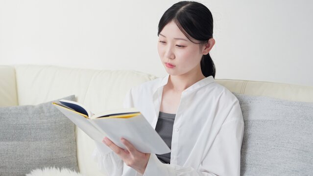 自宅で読書をするアジア人女性