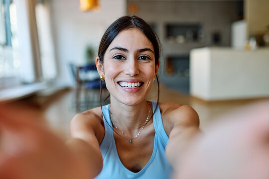 Portrait of a fit blatina girl young woman exercising practicing yoga or fitness taking a selfie with mobile phone camera at home