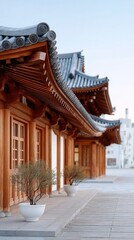 Naklejka premium Close up of traditional wooden temple roof sculptures with intricate details and potted plants in foreground against bright sky