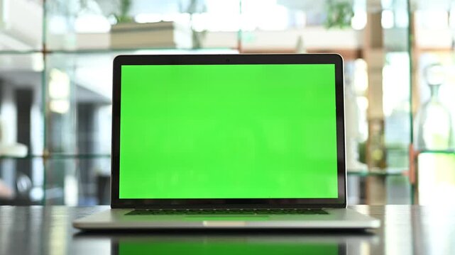 white screen computer or blank monitor laptop on desk restaurant blur background with copy space.