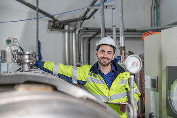 Portrait Engineers or utility staff wearing safety helmet fix the machines in the production line....