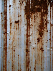 Heavily Rusted Corrugated Metal Sheet with Vertical Rust Streaks and Corrosion Patterns