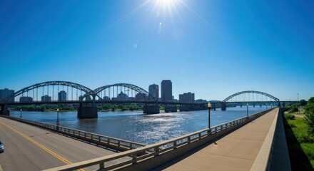 Obraz premium Scenic panoramic view of bridge over river, city skyline under bright, sunny sky
