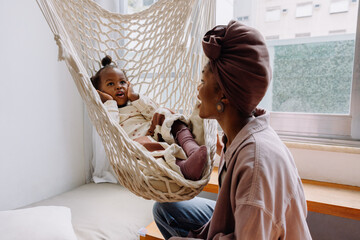 Mother and baby in a hanging hammock indoors