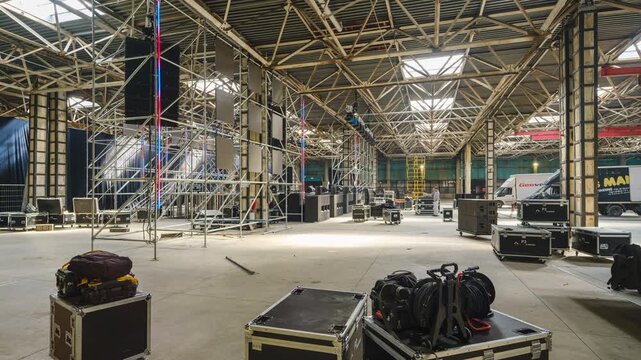 Tbilisi, Georgia - October 2 2025: Timelapse shot of Large Indoor Stage Setup With Scaffolding, Lighting Rigs, and Equipment in Warehouse