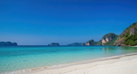 Fototapeta premium A stunning, turquoise-water beach framed by rocky islands under a clear, azure sky