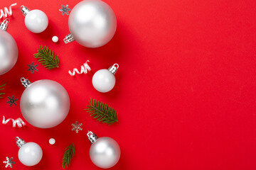 Grey Christmas balls with decor on color background, top view