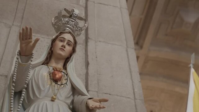 close view of our lady of fatima statue with crown and rosary inside a portuguese church