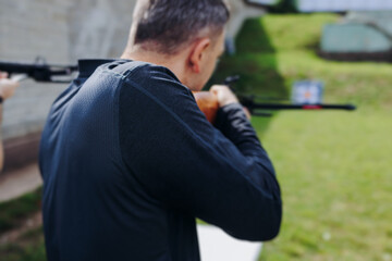 Crossbow shooting and archery at the shooting range, women and men practicing with arbalest at...
