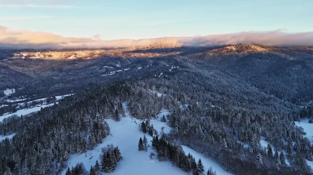 Aerial view during dawn highlights pristine snowfields and serene mountain