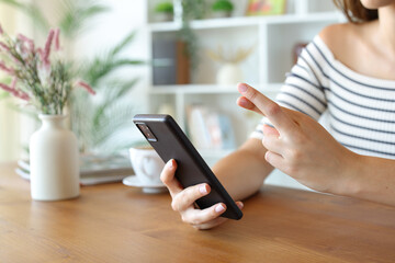 Hopeful woman hands holding mobile phone and crossing fingers