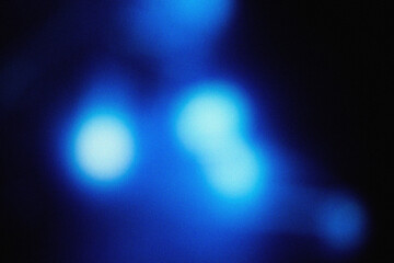 Soft blue illumination with cinematic blur and grainy dust overlay, creating an elegant modern background texture for design, film, and digital art projects