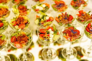 Fresh salads with vegetables and feta cheese in glasses