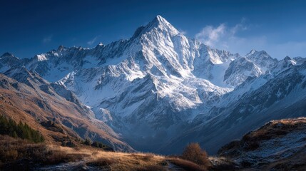 Majestic Snow-Capped Mountain Peak Under a Clear Blue Sky in Autumn